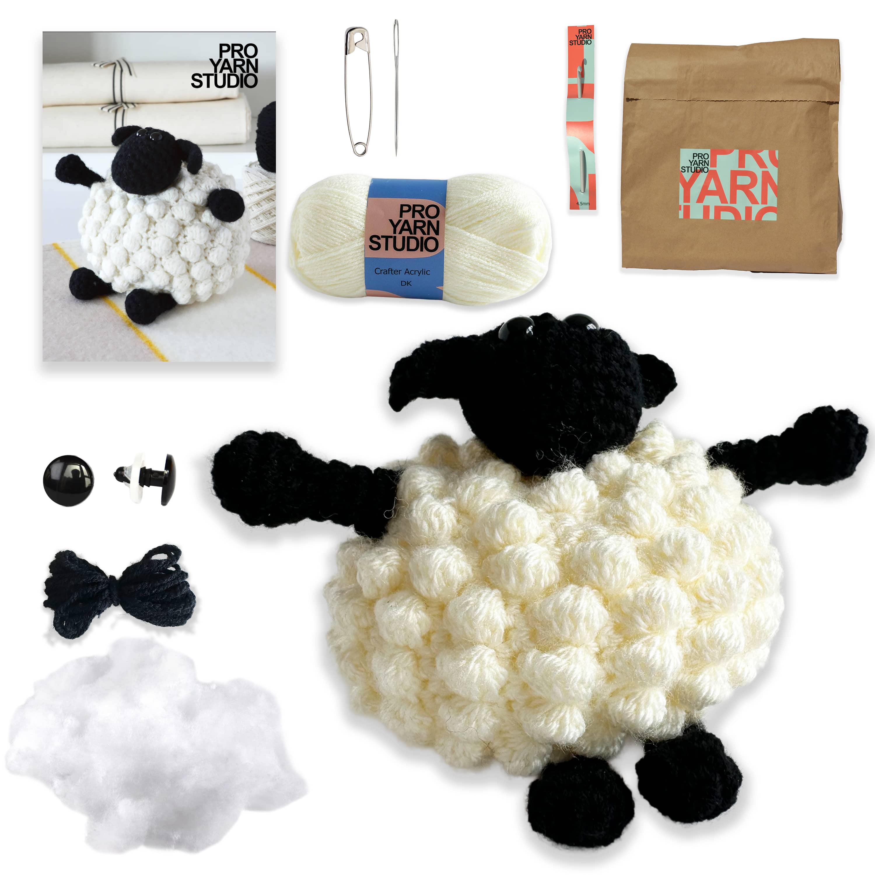 Crochet sheep kit with yarn, black and white wool, and tools on a white background