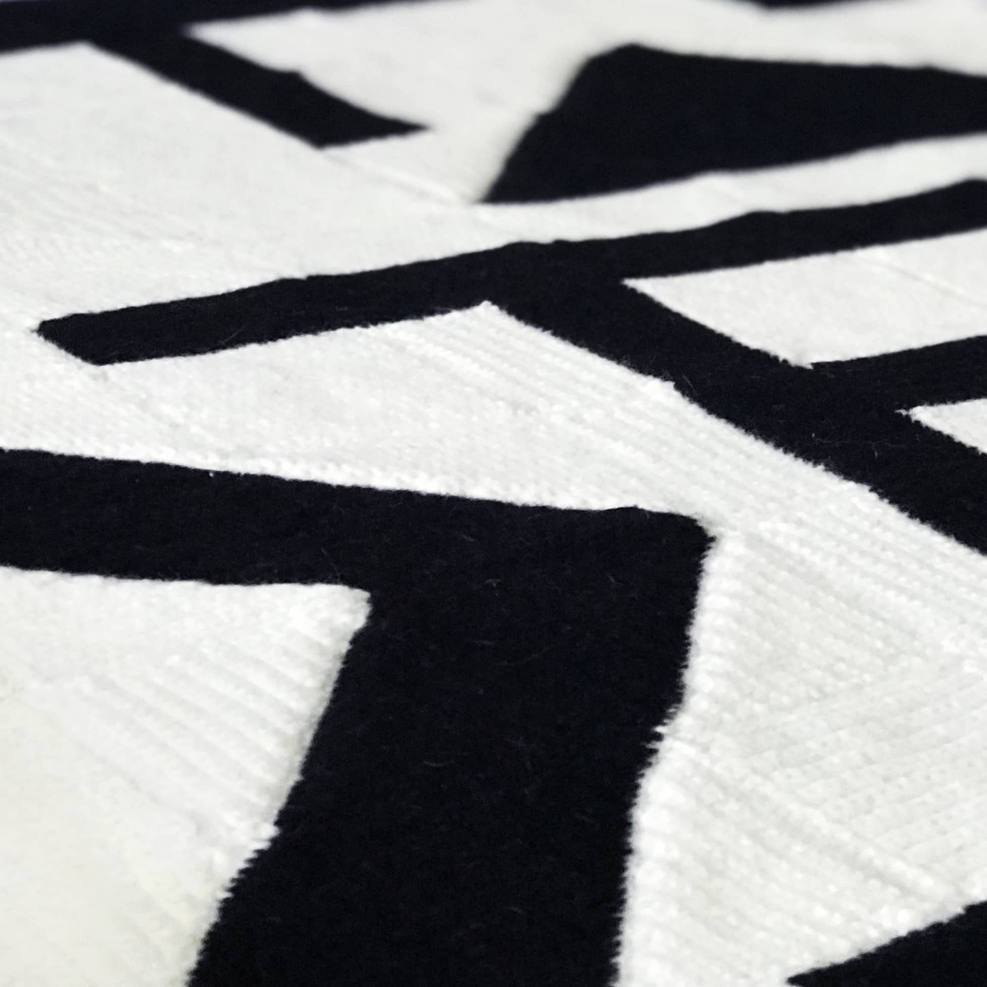 close up of black and white modern art abstract crochet blanket on table