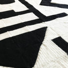 close up of crochet blanket in black and white with a modern art abstract design