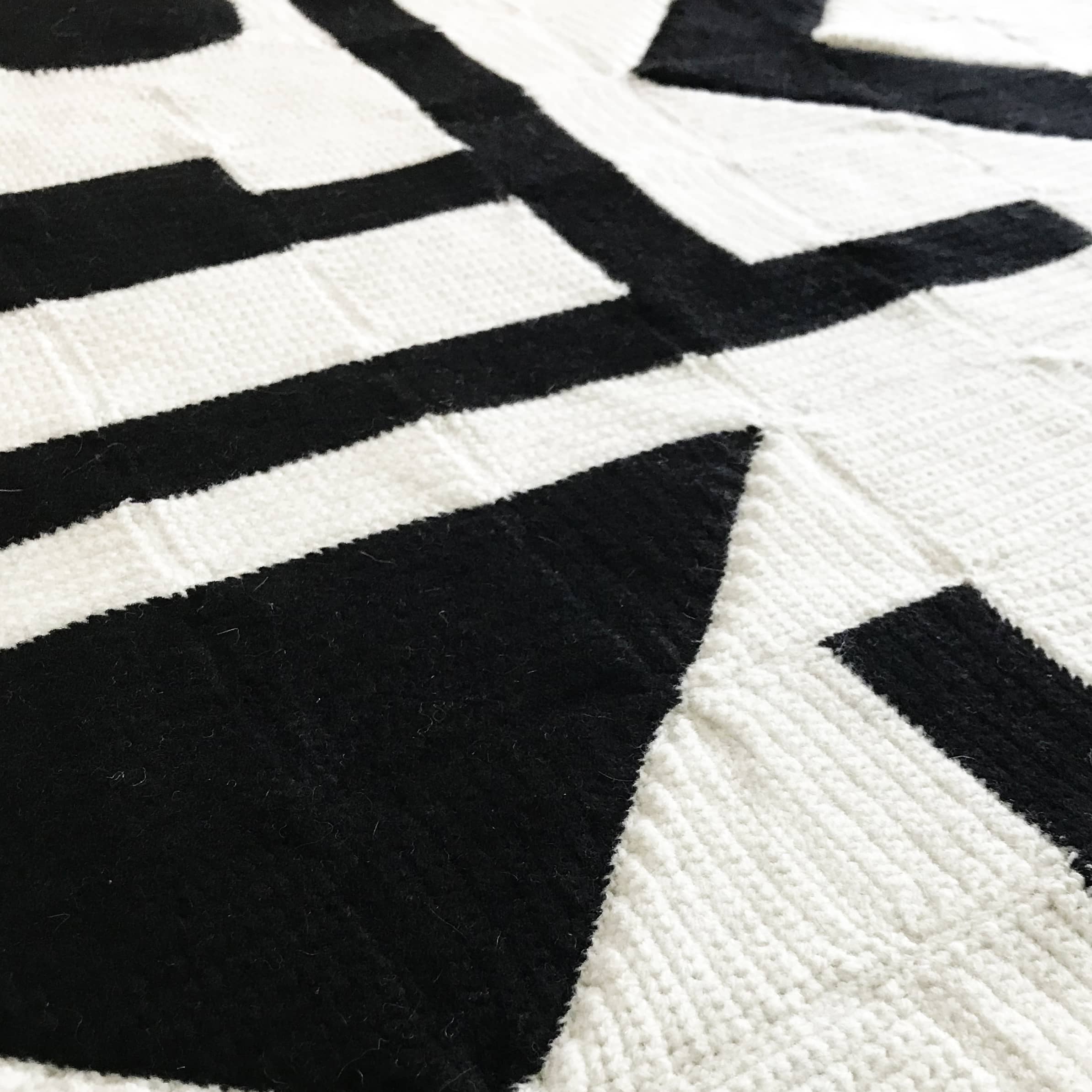 close up of crochet blanket in black and white with a modern art abstract design