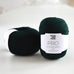 two balls of green yarn on table, 100% pure soft lambswool, british yarn