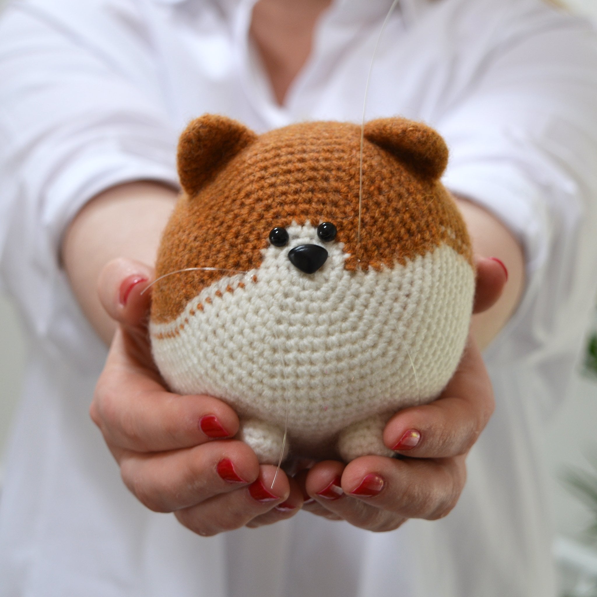 ginger and white amigurumi cat crochet cat completed cat being held up by a woman