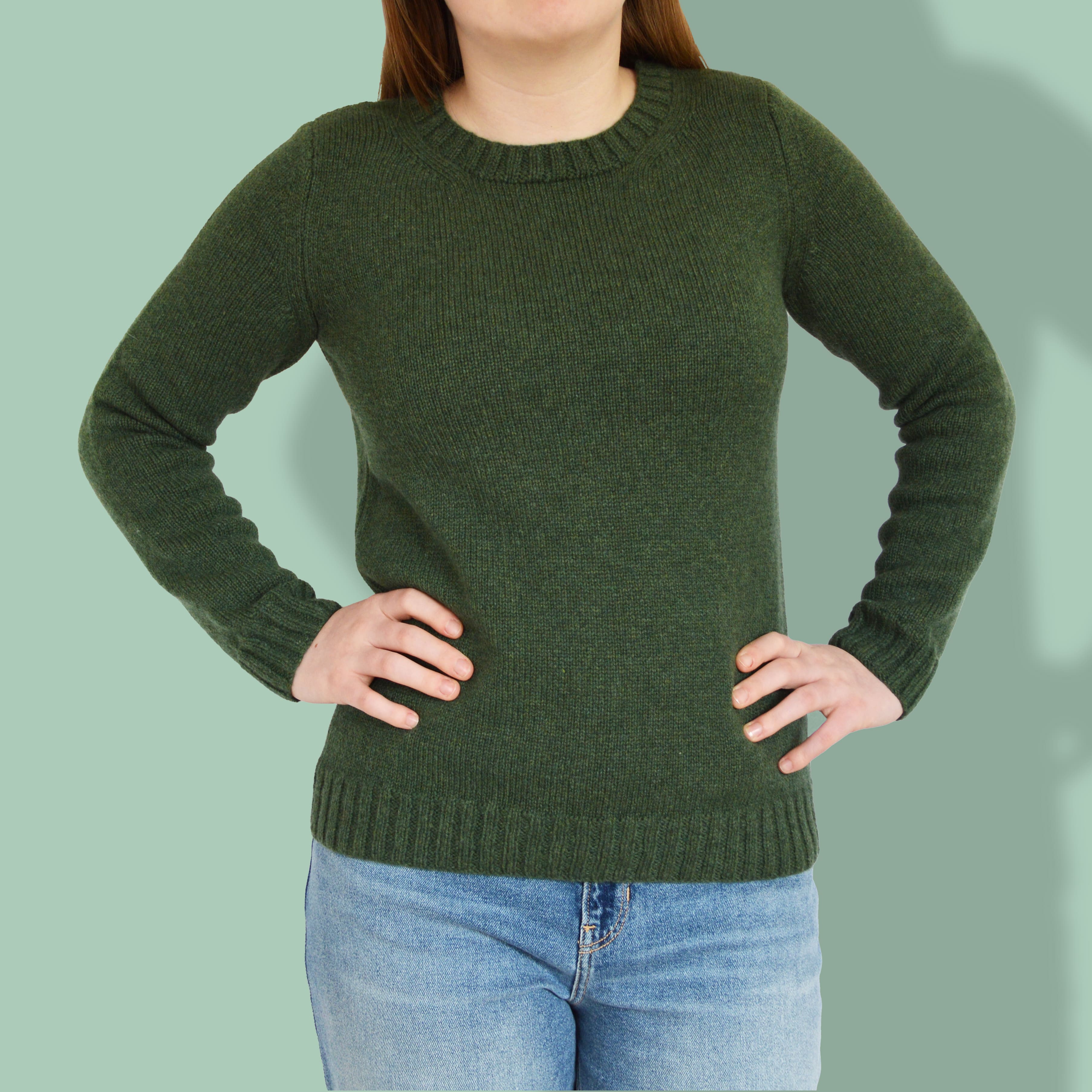 woman wearing green jumper sweater. knitting pattern. knitting kit. crew neck jumper. classic modern knitting pattern.