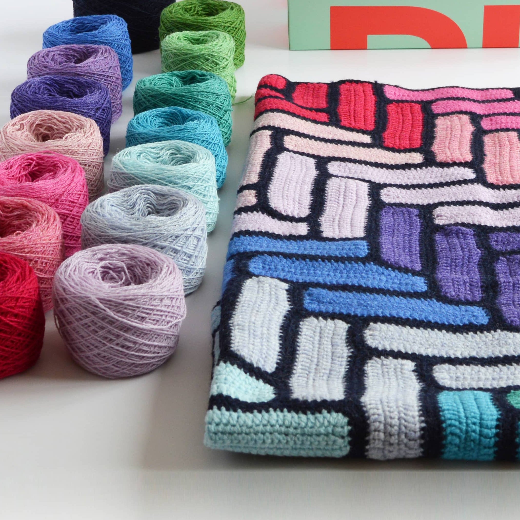 bright colourful crochet blanket kit showing all the yarn colours and box