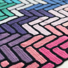 close up of bright modern crochet blanket showing pinks and purples