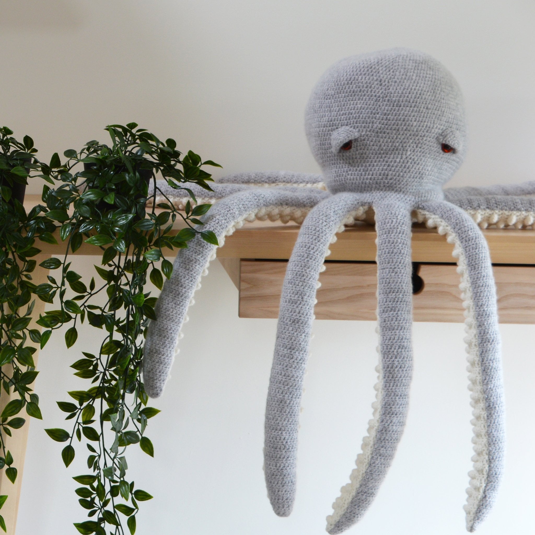 amigurumi octopus crochet kit sitting on table with tentacles dangling