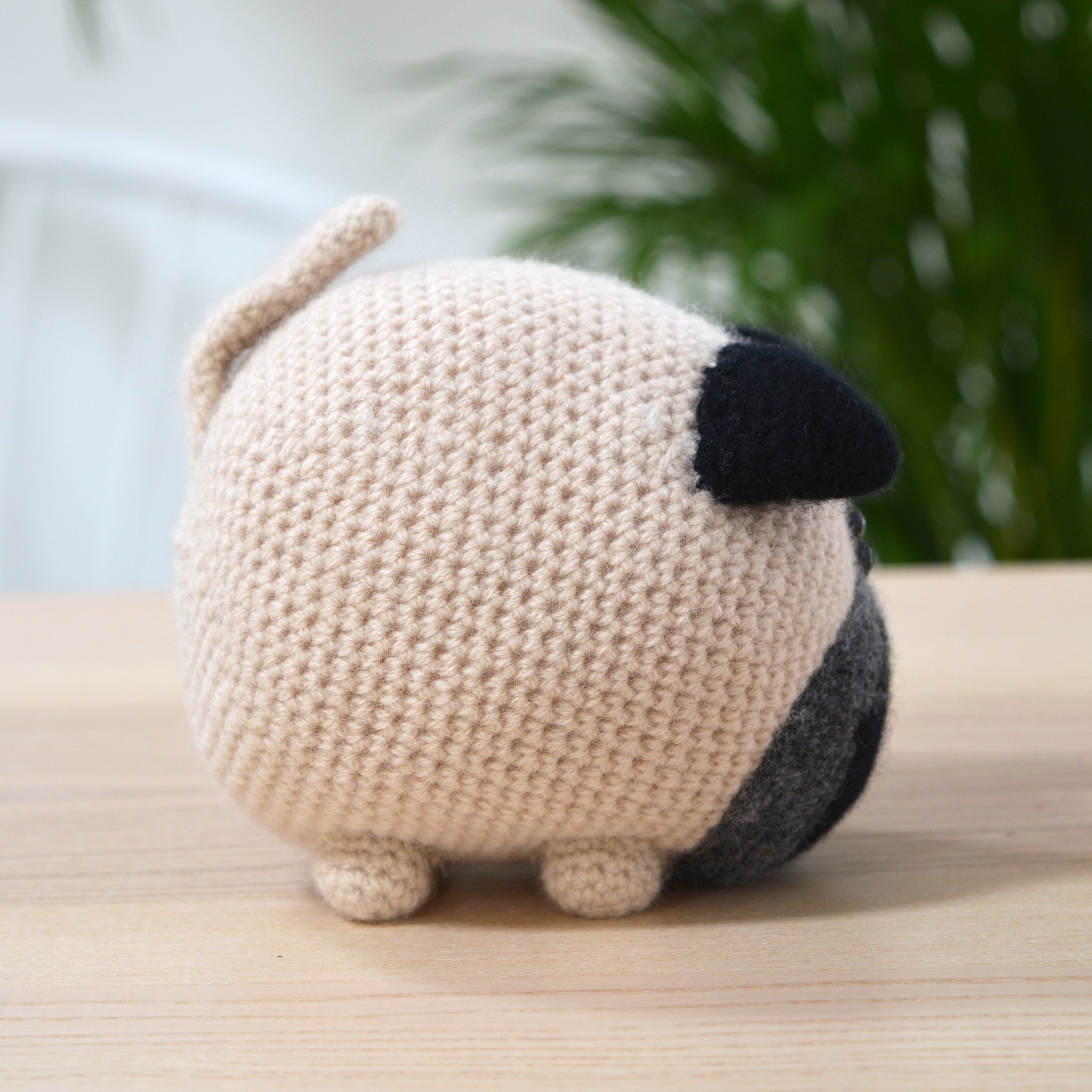 pug crochet kit, amigurumi dog side view on table in modern room setting