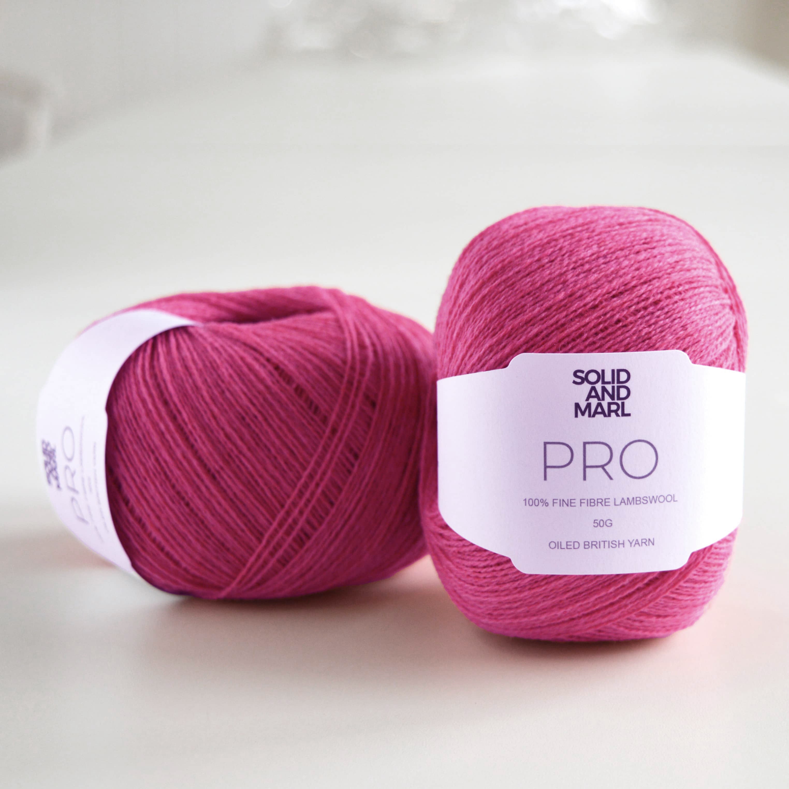 ball of knitting wool on table. bright pink knitting yarn. british wool. pure lambswool