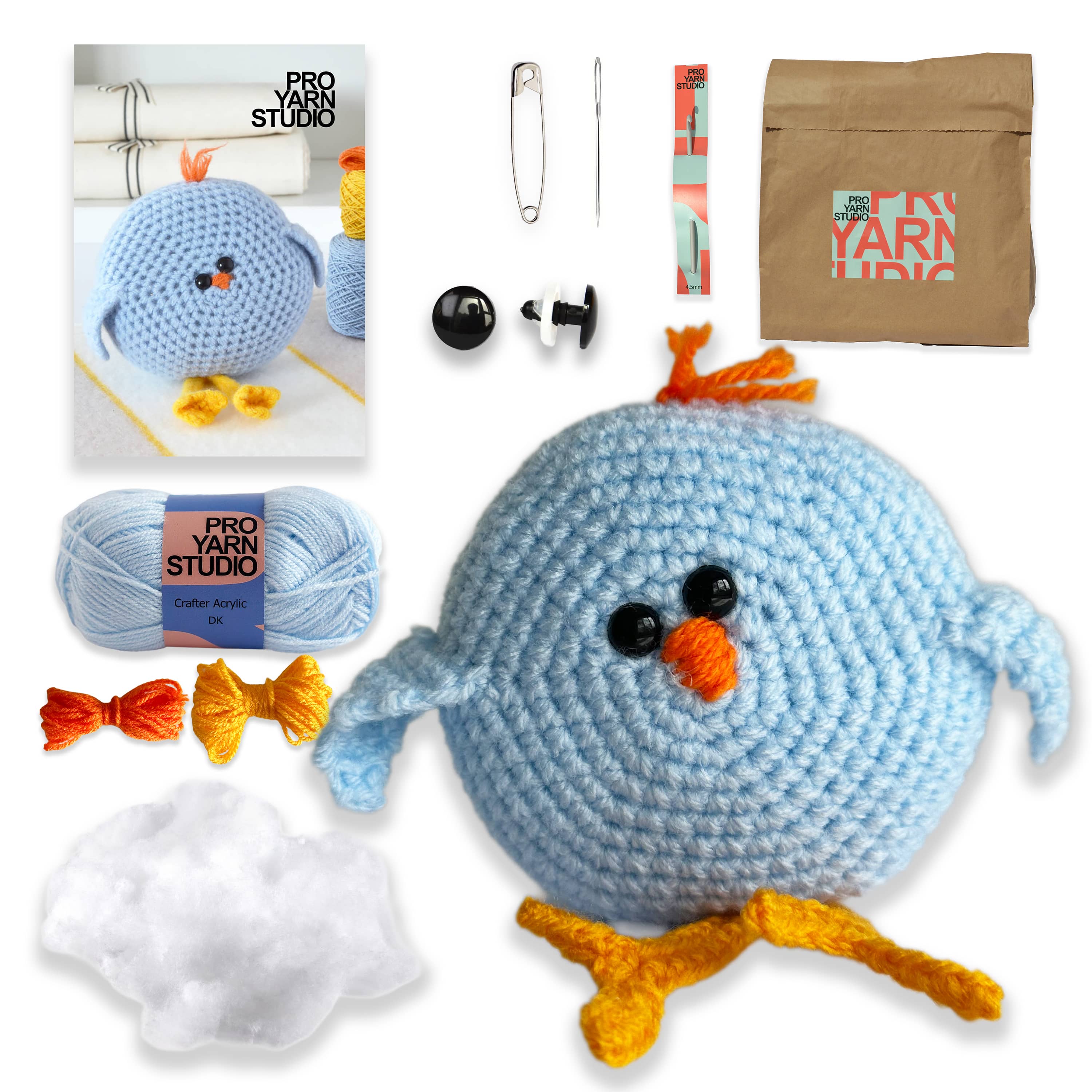 Crocheted blue bird toy with yarn, needles, and packaging on a white background