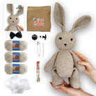 Crochet bunny kit with yarn, needles, and other supplies on a white background
