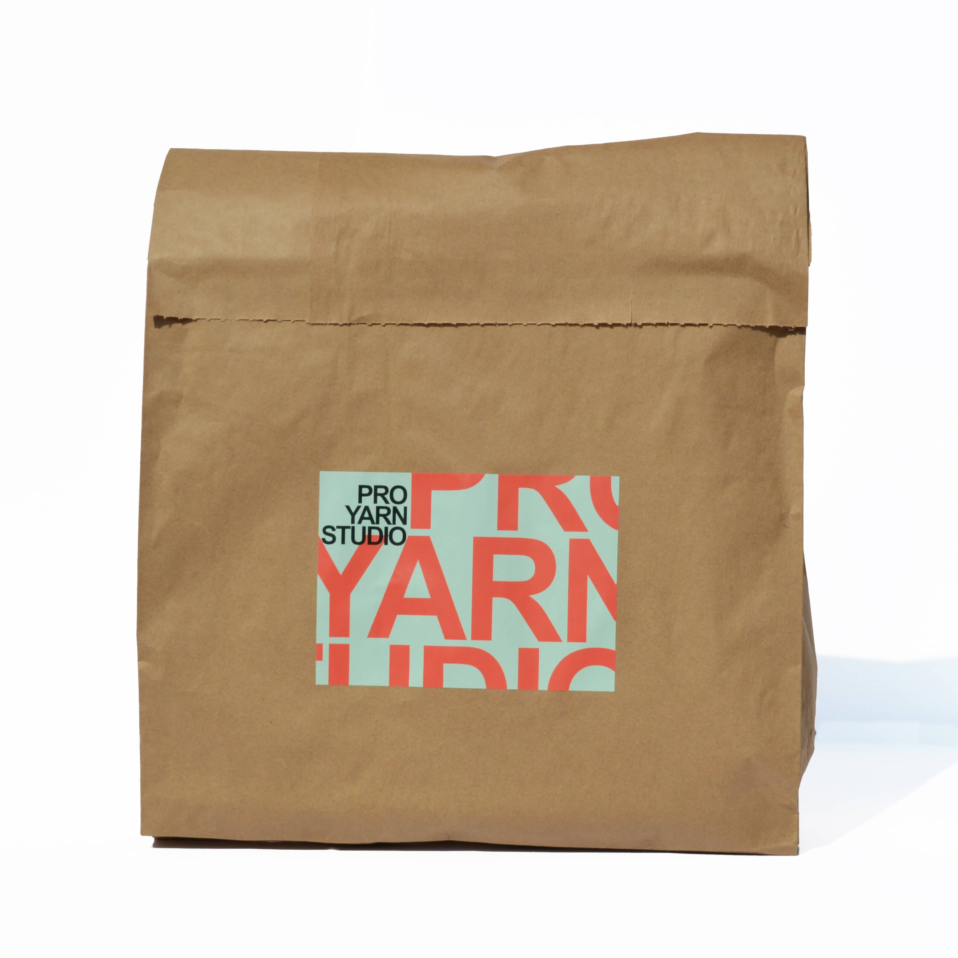 Brown paper bag with 'Pro Yarn Studio' logo on a white background
