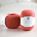 ball of coral colour yarn on table. pro yarn, pure wool, real wool, british yarn