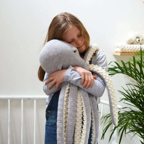 child cuddling large amigurumi octopus crochet kit, completed octopus in grey and white