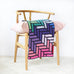 bright coloured crochet blanket on chair