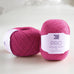 ball of knitting wool on table.  bright pink knitting yarn.  british wool. pure lambswool